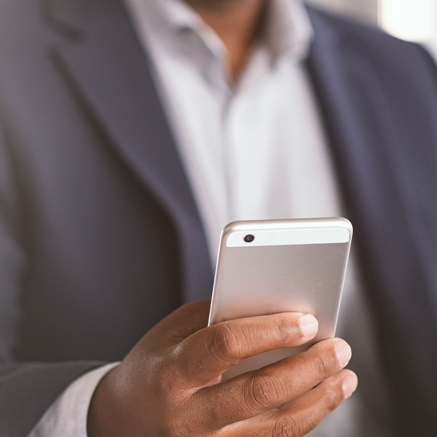 Close up of black businessman hand holding smartphone while work