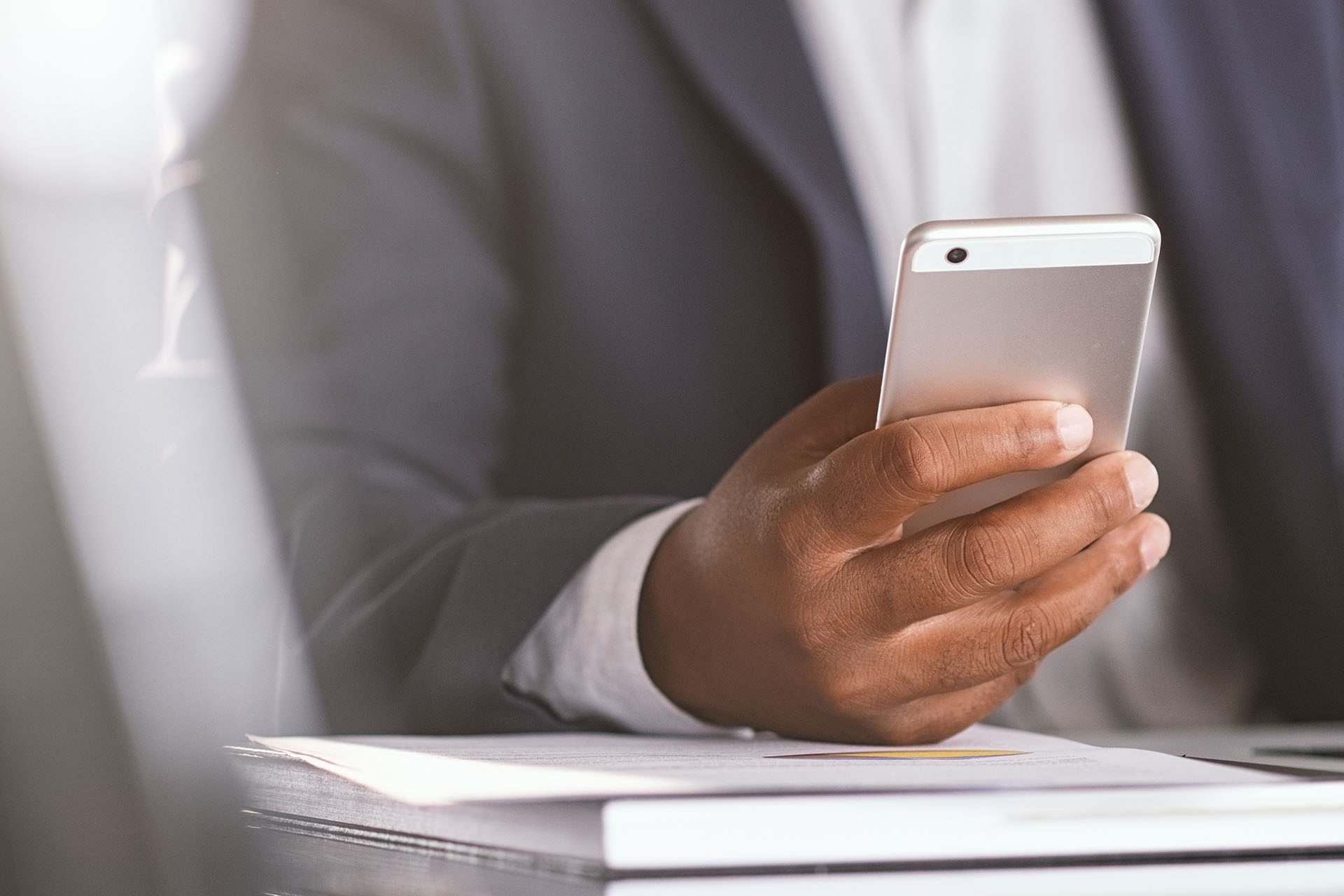 Close up of black businessman hand holding smartphone while work