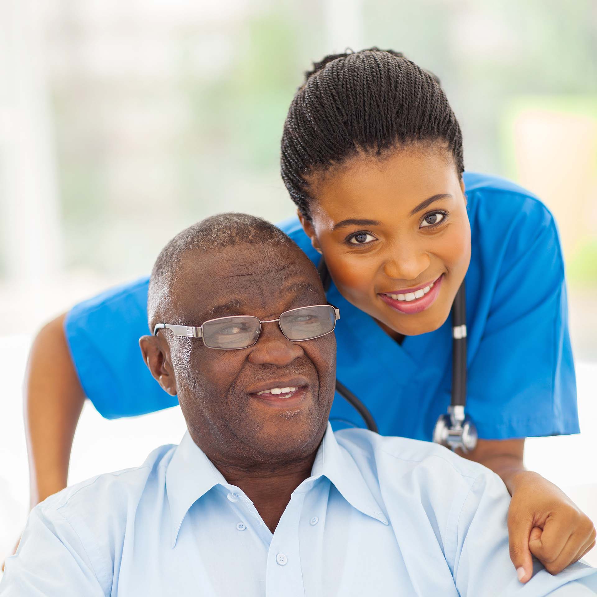 elderly african american man and caring young caregiver at home