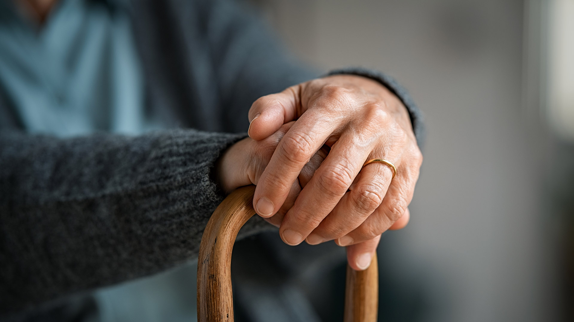 Close up of senior disabled woman hands holding cane