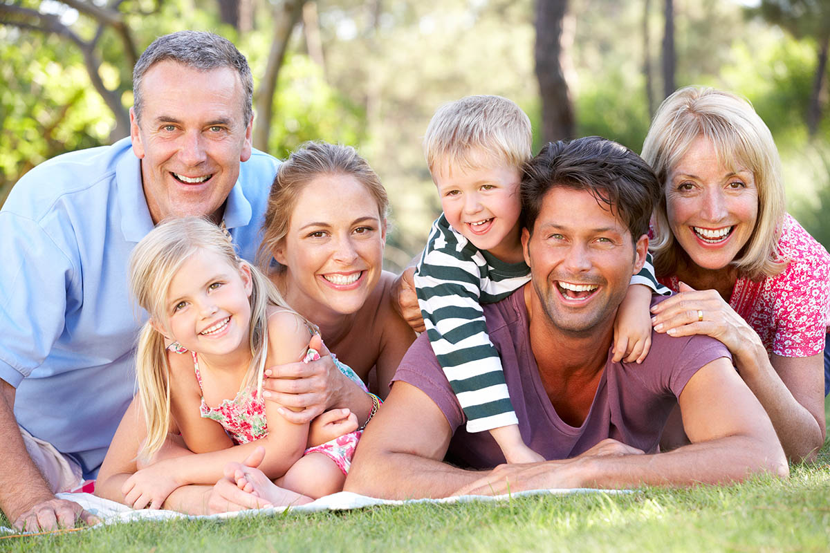 Extended Family Group Relaxing In Park Together